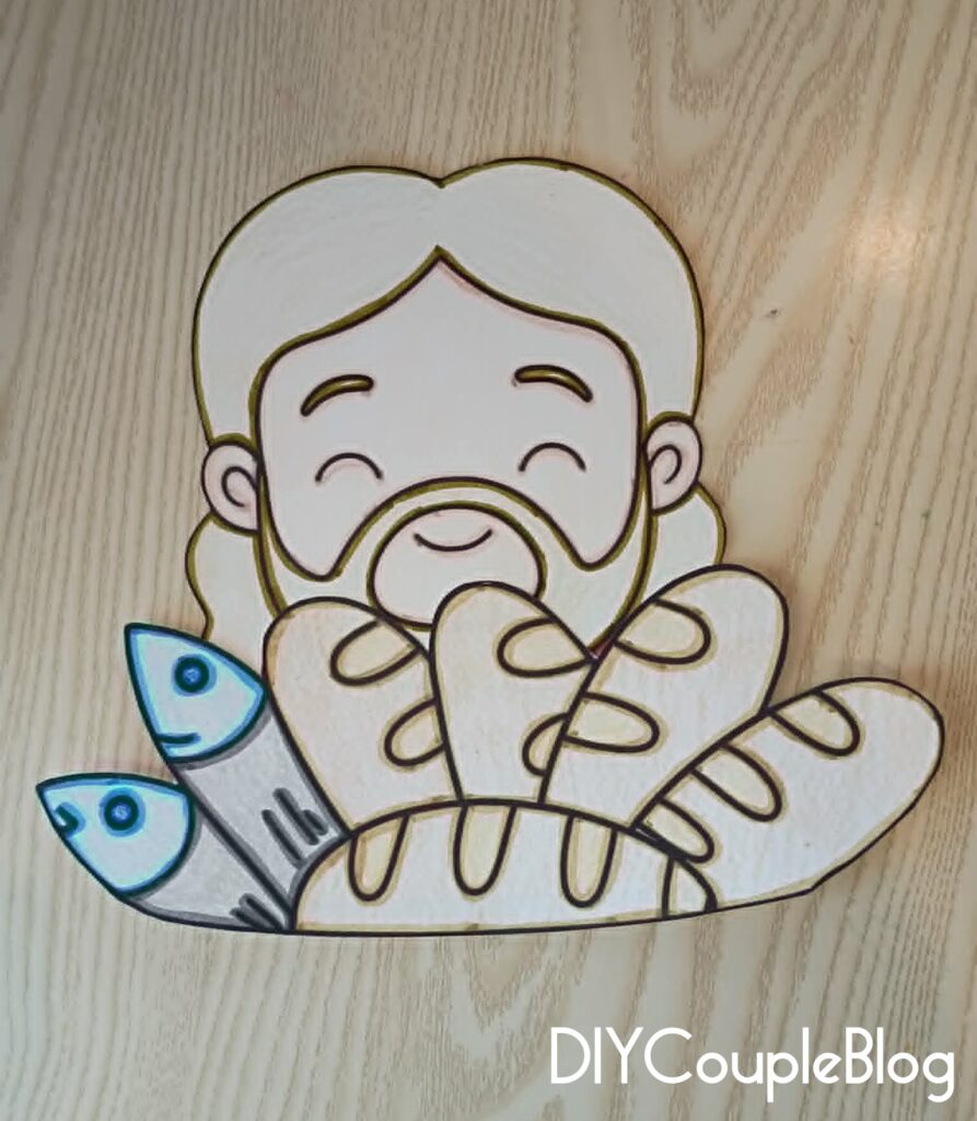 gluing loaves and fishes to the front of Jesus to make a loaves and fish craft 