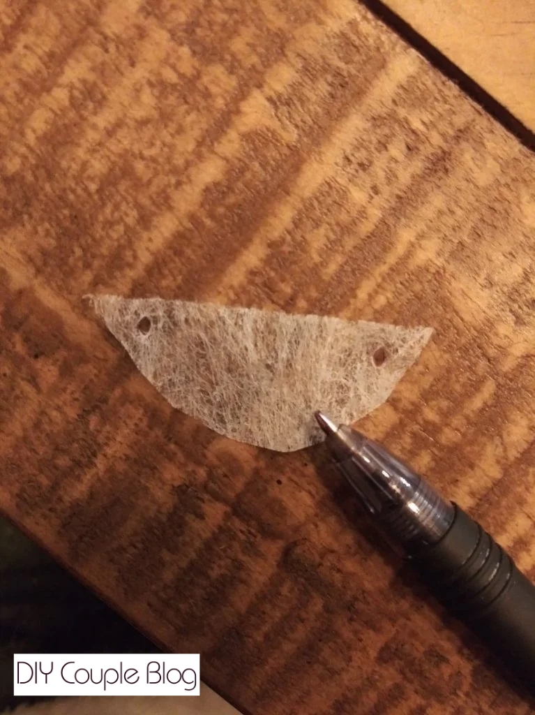 putting holes through the corners of a dryer sheet 