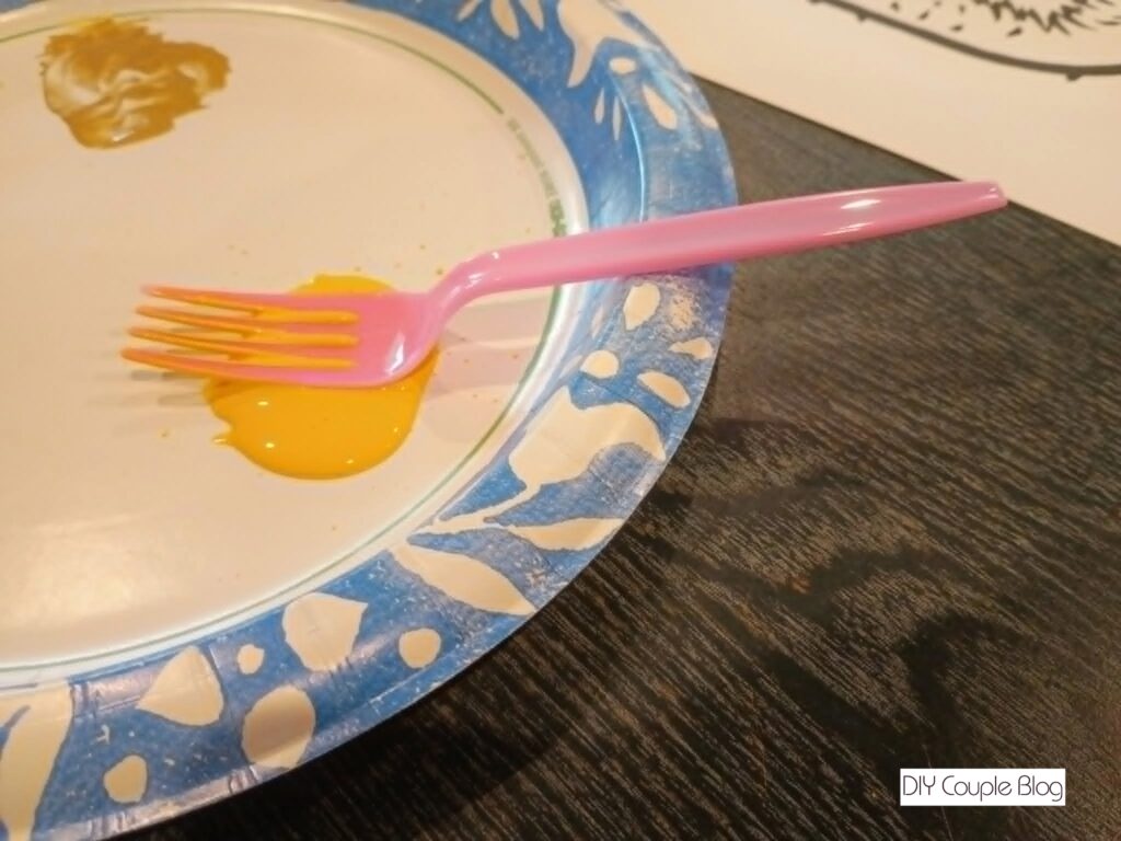 plastic fork laying in yellow paint 
